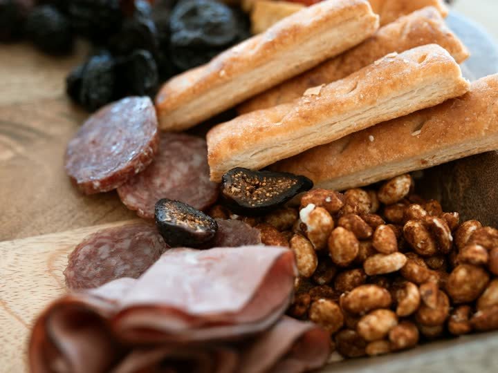 Plateau apéritif : tranches de saucisson, gressins, figues séchées et noisettes