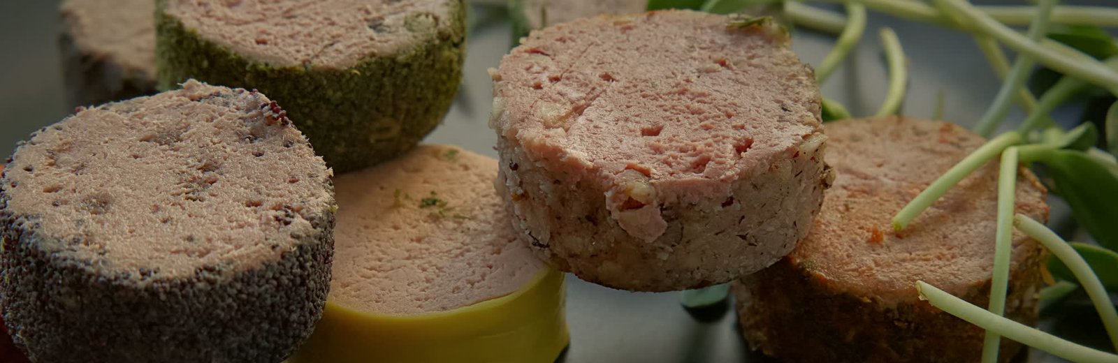 Terrines et pâtés maison alignés, croûtes au poivre, aux herbes et aux pistaches